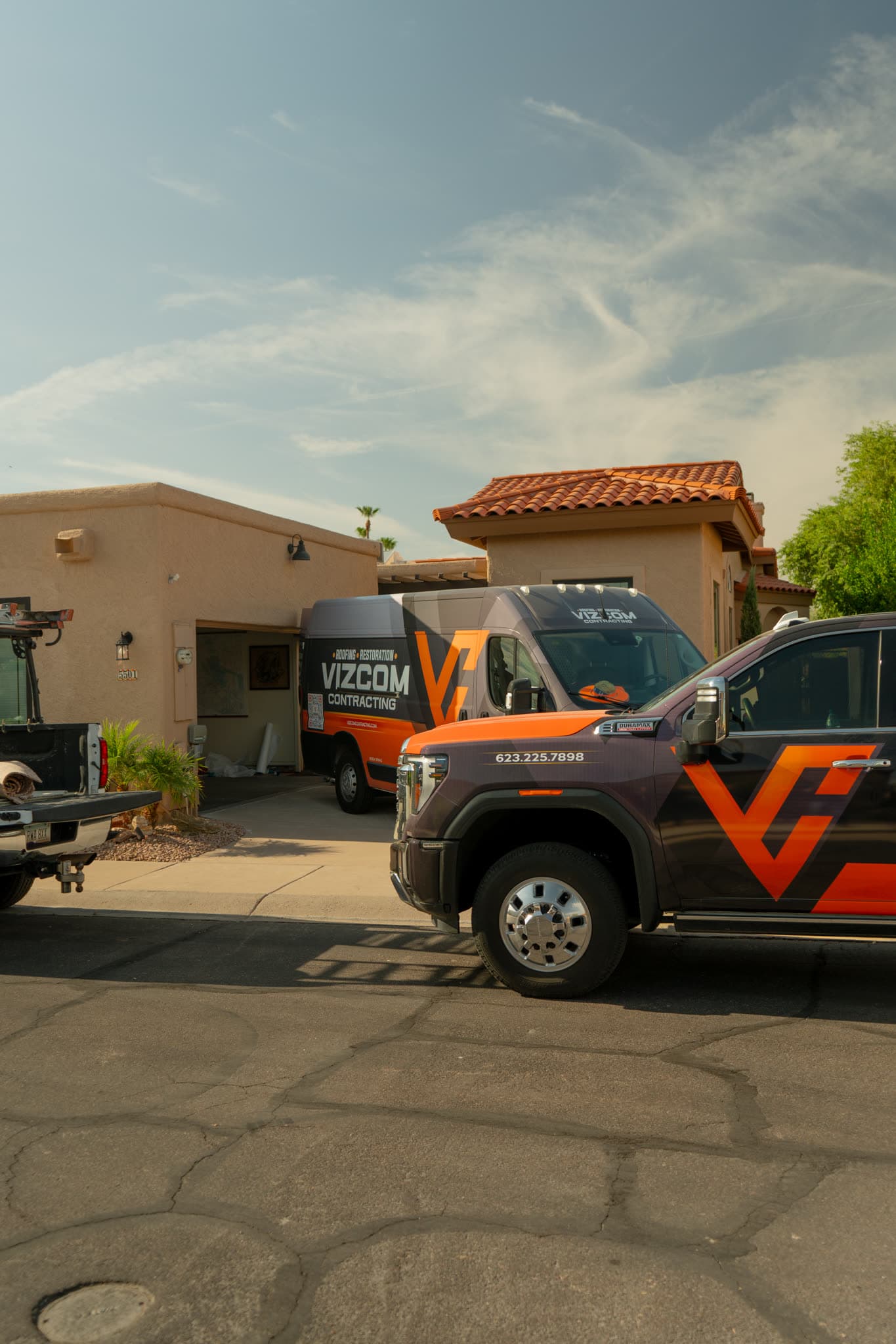 Vizcom Contracting truck and wrapped van parked at a Phoenix home during a job.