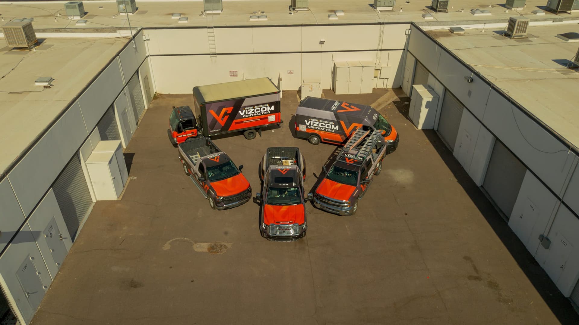 The Vizcom Contracting fleet of wrapped trucks and vans lined up at the company yard