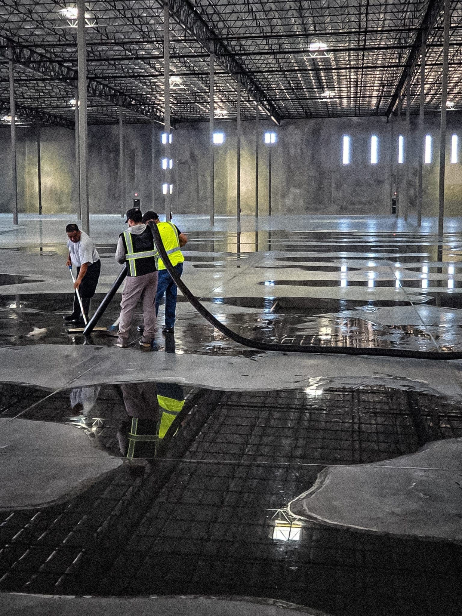 Vizcom Contracting crew extracting standing water from a commercial warehouse floor.